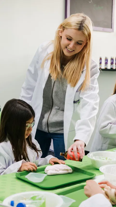 Staff member guiding students through experiment