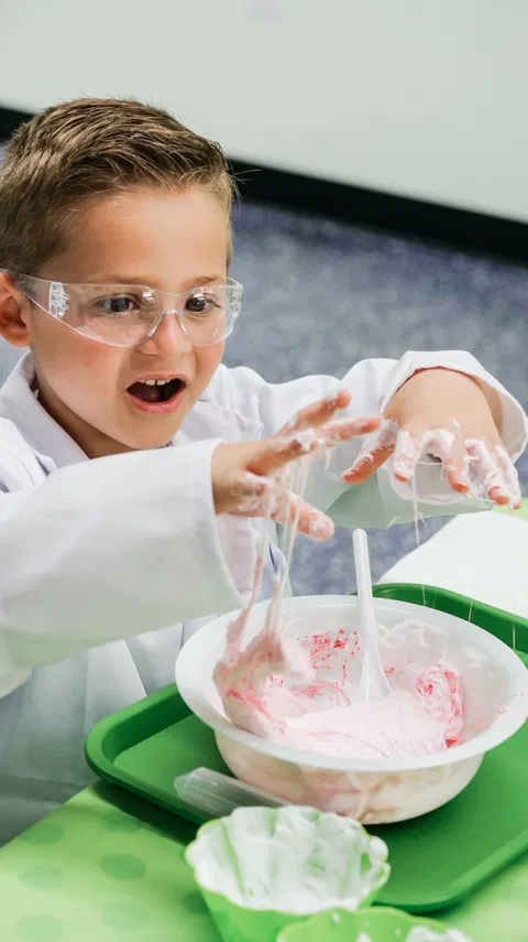 Excited child playing with colorful slime at Reaction Lab