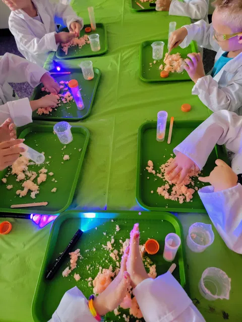 Children working on science experiments at green trays