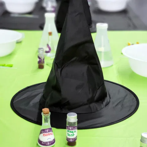 Witch hat and potion bottles on a green lab table