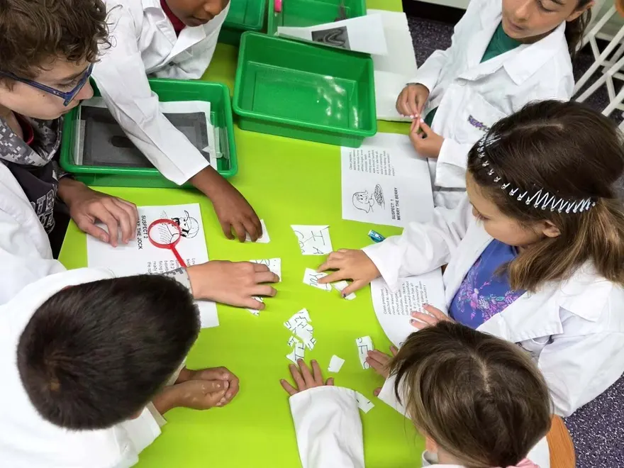 Kids in lab coats testing mystery powders at Reaction Lab